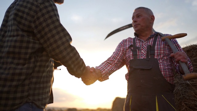 一位资深农民和一位农学家在一块农地上握手达成协议视频下载