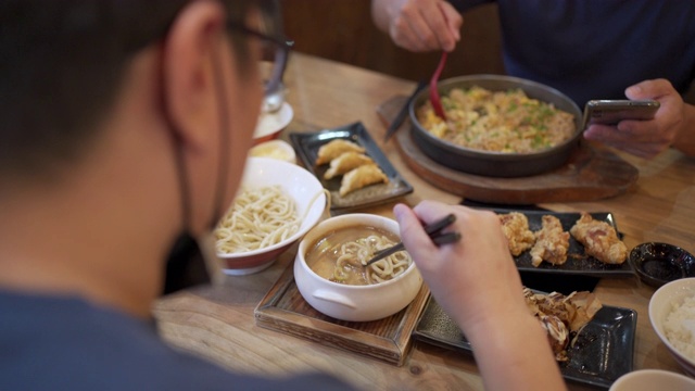 两名男子戴着面具在日本餐厅用餐，这是新常态视频下载