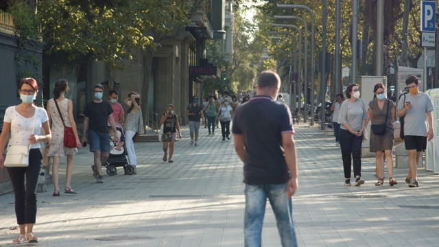 巴塞罗那新常态的城市生活。2020年夏天，人们在大街上戴着口罩视频素材