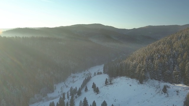 无人机拍摄的美丽的冬季风景在日落时的山脉和森林。视频素材