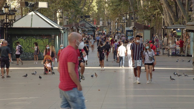 2019冠状病毒病期间巴塞罗那大街上戴口罩的人群。2020年夏天的兰布拉斯标志性街道视频素材