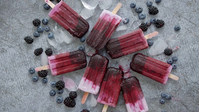 自制黑莓和奶油冰淇淋或冰棒与冷冻浆果在黑色板岩托盘视频素材