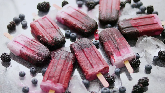 自制黑莓和奶油冰淇淋或冰棒与冷冻浆果在黑色板岩托盘视频素材