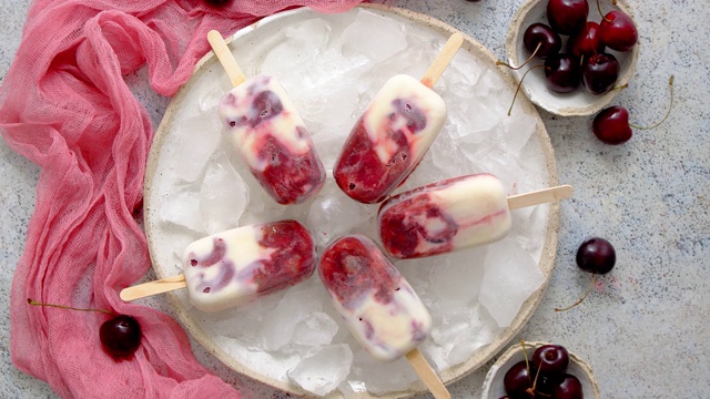新鲜的奶油和樱桃自制冰棒放在白色的陶瓷盘子上，还有水果和纺织品视频素材