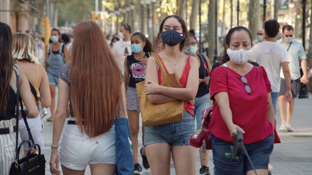 巴塞罗那新常态的城市生活。在街上戴口罩是强制性的。2020年夏天的格拉西亚大道视频素材