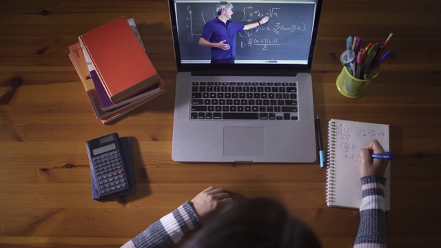 学生通过教育视频电话与数学老师在笔记本电脑上学习。由于冠状病毒大流行，在线在线学习视频下载