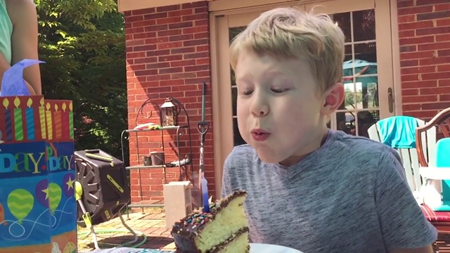 SLO MO小男孩吹灭生日蛋糕上的蜡烛(音频)视频素材