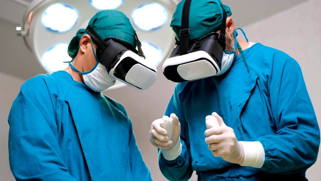 一个外科医生的特写镜头戴上增强现实眼镜在高科技医院执行最先进的外科手术的状态。在手术室工作的医生和助手。视频下载