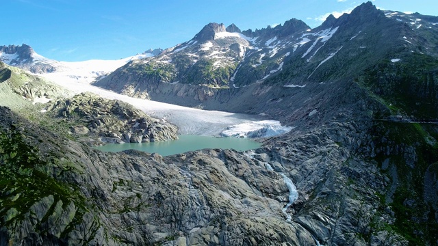 在冰川山谷附近的一个湖泊，美丽的冰川景观下的蓝天——用4K无人机鸟瞰视频素材