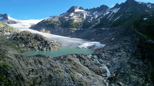 山谷里的冰川，中间有个湖。美丽的自然景观下的蓝天-无人机4K鸟瞰视频素材