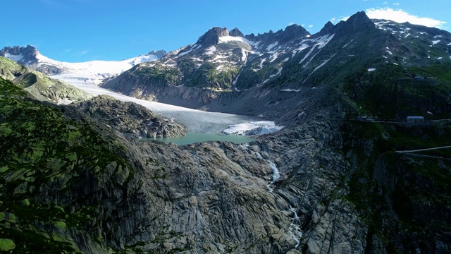 山谷里的冰川，中间有个湖。美丽的自然景观下的蓝天-无人机4K鸟瞰视频素材