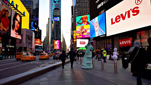 演员打扮成自由女神像在时代广场。人们在剧院区走过。视频下载