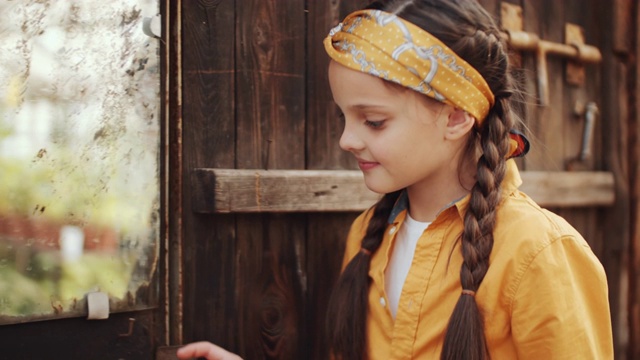 快乐的小女孩在温室农场的生锈的镜子里视频素材