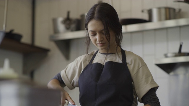 低角度的女人切片黄瓜在商业厨房/ Orem，犹他州，美国视频下载