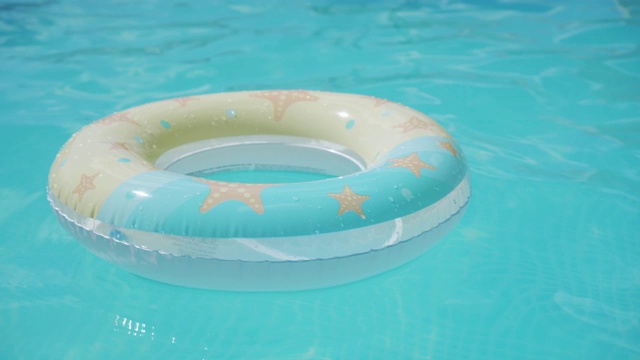 充气的圆圈漂浮在蓝色透明的水面上。背景概念的夏季水上休闲。空池。视频下载