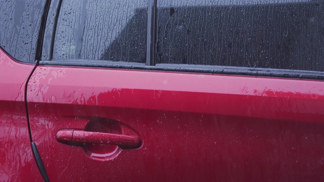 雨点落在停车场白天的车上。视频素材