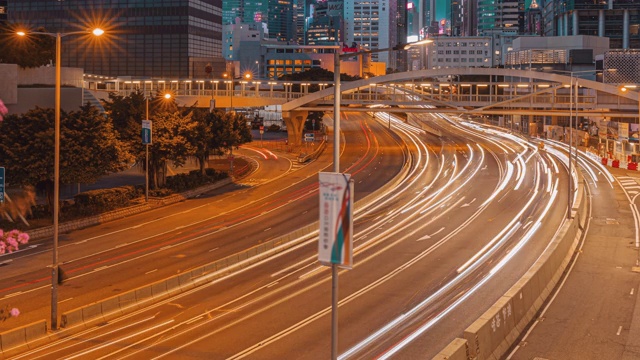 从现代大厦下的道路上的交通灯在白天到晚上的时间在香港城市景观视频素材
