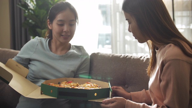 亚洲朋友女人在家吃披萨视频素材