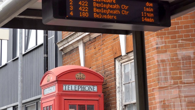 一张倾斜的公共汽车时刻表和电话亭的照片。视频下载
