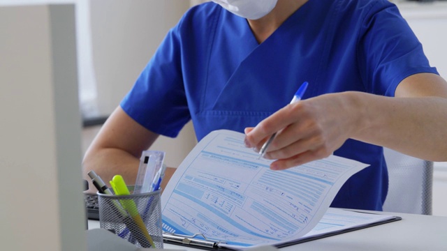 医生或护士戴着带剪贴板的口罩在医院视频下载