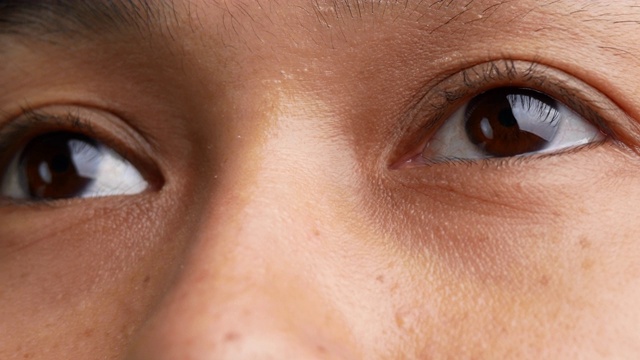近距离的亚洲女人眨眼的眼睛和小雀斑在她美丽的脸上。视频素材