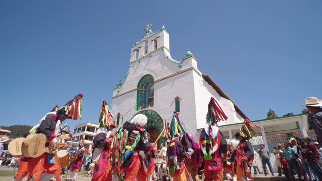 在小镇的传统节日期间，男子们穿着五颜六色的传统服装在圣胡安查穆拉教堂前跳舞和弹奏吉他视频下载