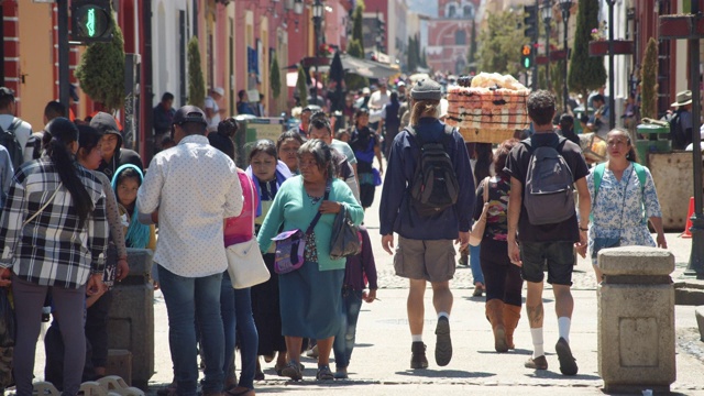 一群行人走在墨西哥恰帕斯市圣克里斯托巴尔德拉斯卡萨斯市中心的步行街上视频下载