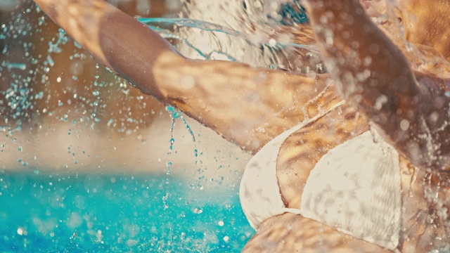 超级慢MO女人享受在游泳池洒水器下视频素材
