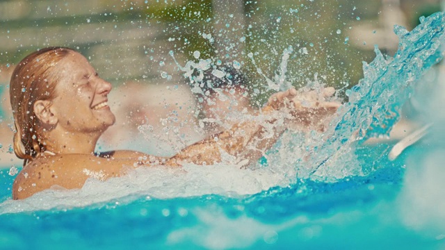超级慢动作莫女人在游泳池洒水器下溅水视频素材