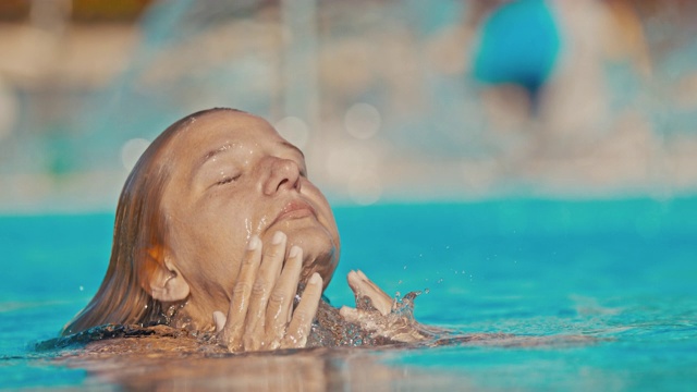 超级慢动作的女人把她的头伸出水池的水视频素材