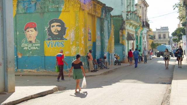 在古巴哈瓦那一个拥挤的街角，乌戈·查韦斯和切·格瓦拉的肖像画在墙上视频下载