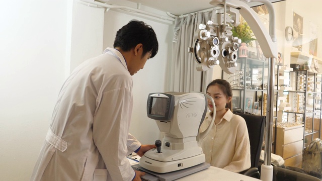 男验光师用机器检查女病人的视力视频下载
