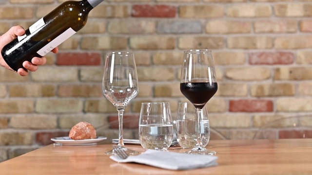 在优雅的餐厅里，服务员正在倒一瓶红酒。高质量的全高清镜头视频下载