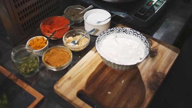 一个不知名的男厨师将切好的番茄片加到一道酸奶油菜上的特写视频下载