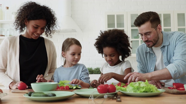 微笑的多种族家庭参与烹饪与不同的孩子。视频素材