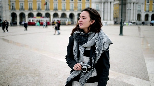 微笑沉思的女游客穿着大衣和围巾视频素材