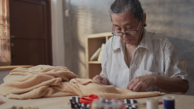 女裁缝高级妇女缝纫织物修补毛毯视频素材