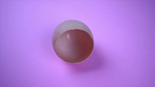 空的破碎的棕色蛋壳，紫色背景视频下载