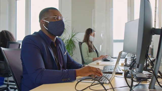 商人戴着防护面具在办公桌前工作视频下载