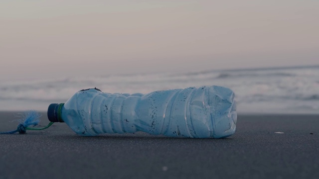 塑料瓶被扔在海滩上。环境污染视频素材