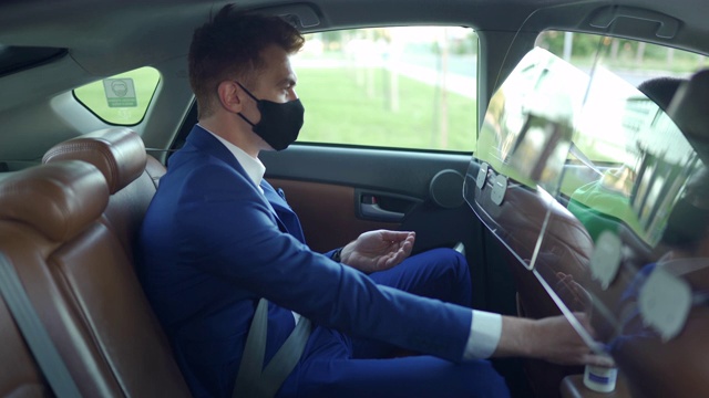 的士司机戴上防护口罩，用消毒剂消毒双手视频素材