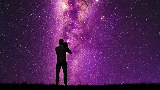 一个男人的剪影用摄像机记录下银河和流星视频下载