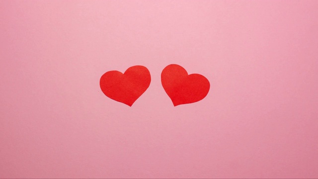粉红色背景上两颗红心。情人节视频下载