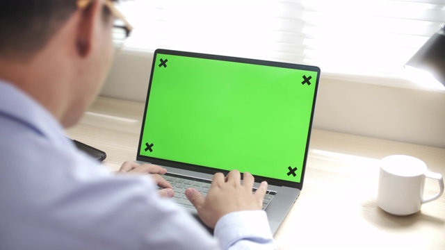 在家里用绿屏幕笔记本电脑的人视频素材
