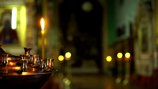 金色烛台上有一支燃烧的蜡烛，背景是东正教视频素材