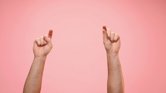 在粉红色的背景上，一个年轻人举起手指，竖起大拇指视频下载