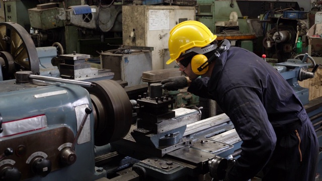 一名白人男子在一家工业工厂的机器上工作。视频下载