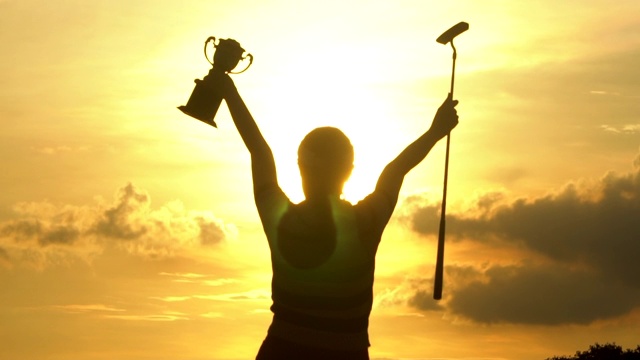 在日落时拿着奖杯的高尔夫锦标赛冠军视频素材