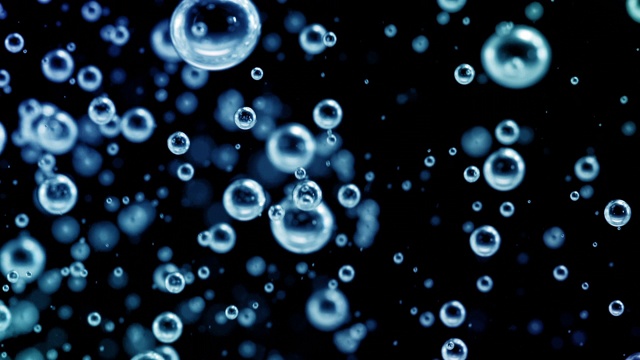 近距离的蓝色小气泡流动下的黑色背景下的水视频素材