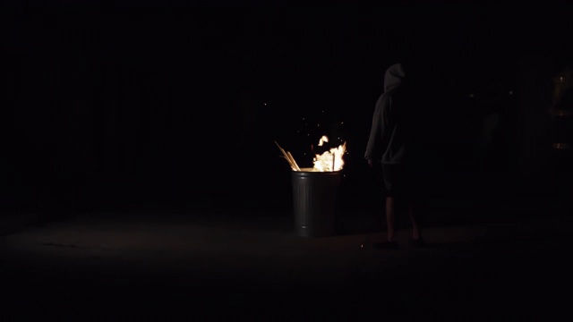穿着帽衫的神秘男子站在燃烧的火焰上视频下载